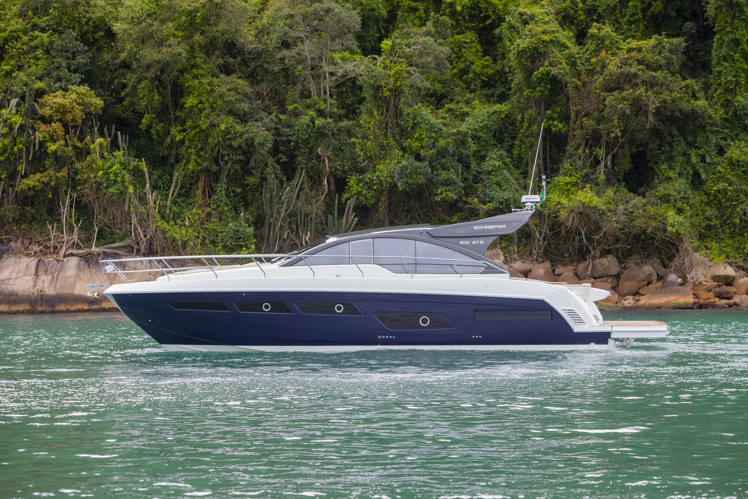 Schaefer 510 GTS at anchor beneath a forested headland