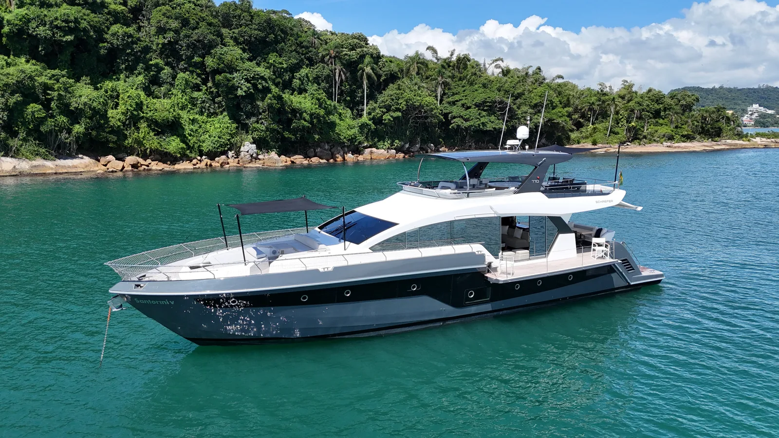 Schaefer 770 cruising along a forested coastline