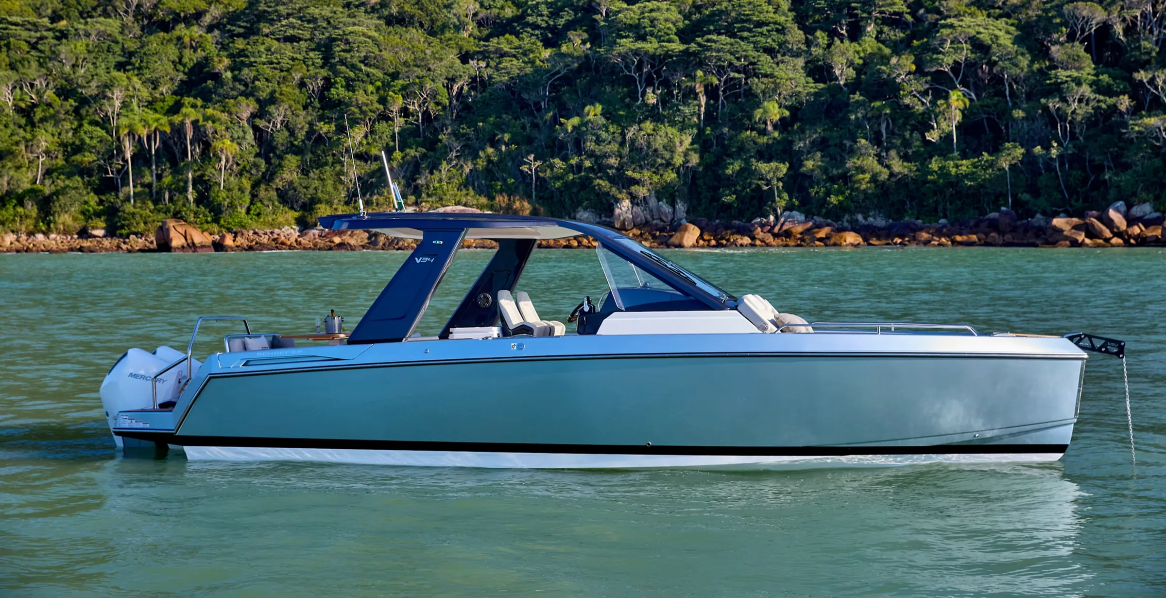 Schaefer V34 at rest on calm water with a forested shoreline behind