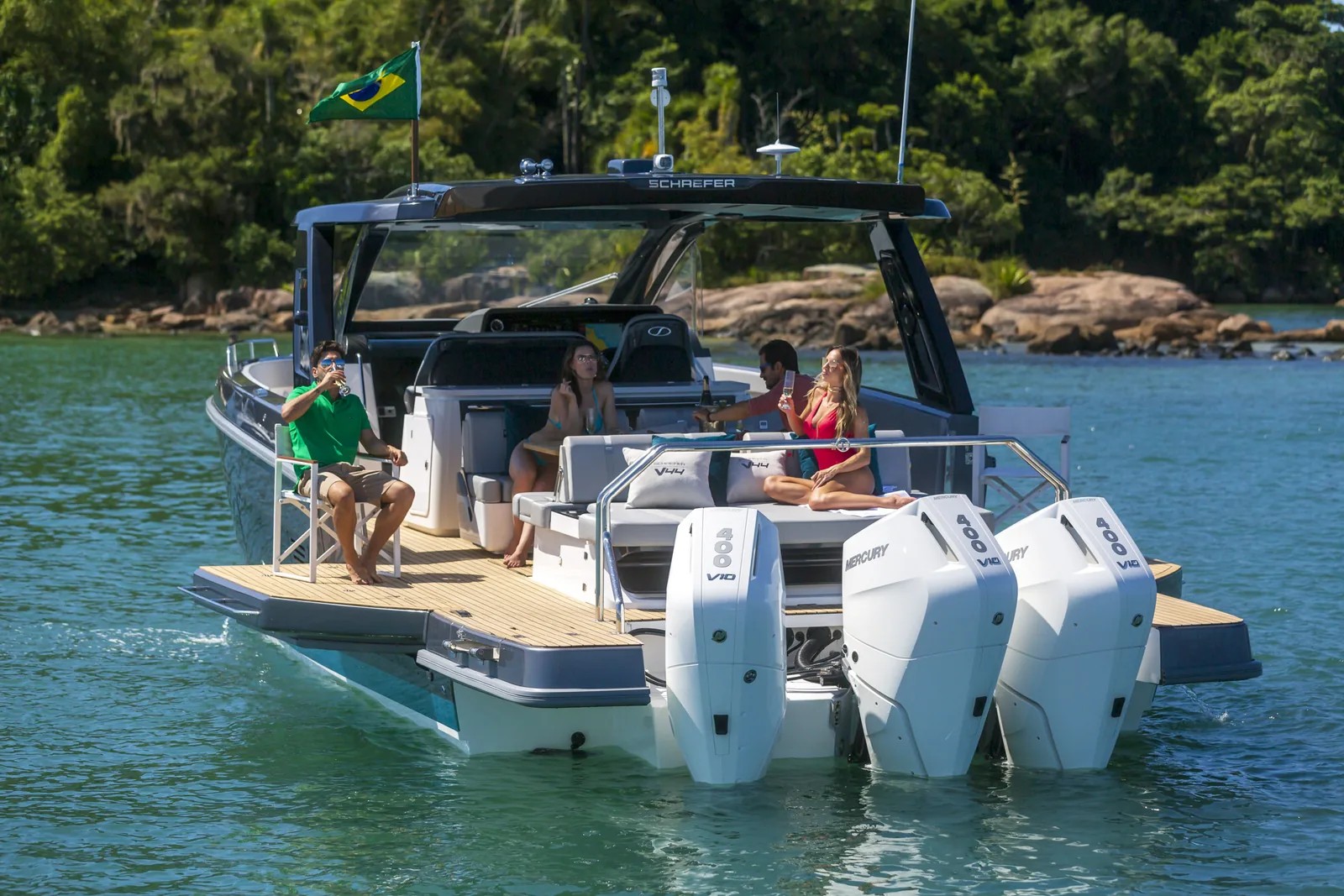 Stern of the Schaefer V44 with triple outboards, balconies open and guests on deck