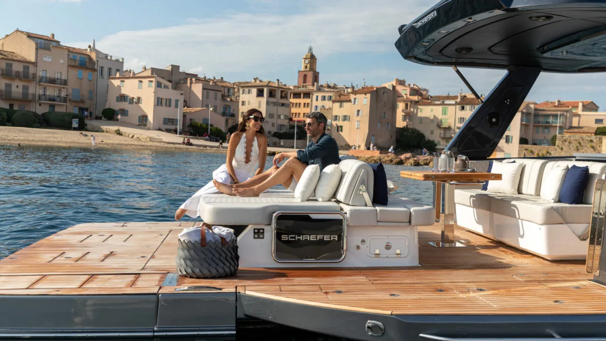 Guest on the aft deck of the Schaefer V44 with a harbour town behind